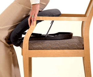 A senior standing up with the help of a portable lifting cushion